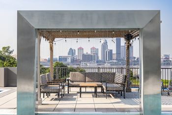 A patio with a table and chairs overlooking a city skyline.